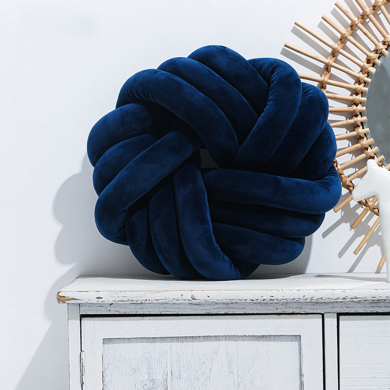 Knotted ball cushion in navy blue on sofa